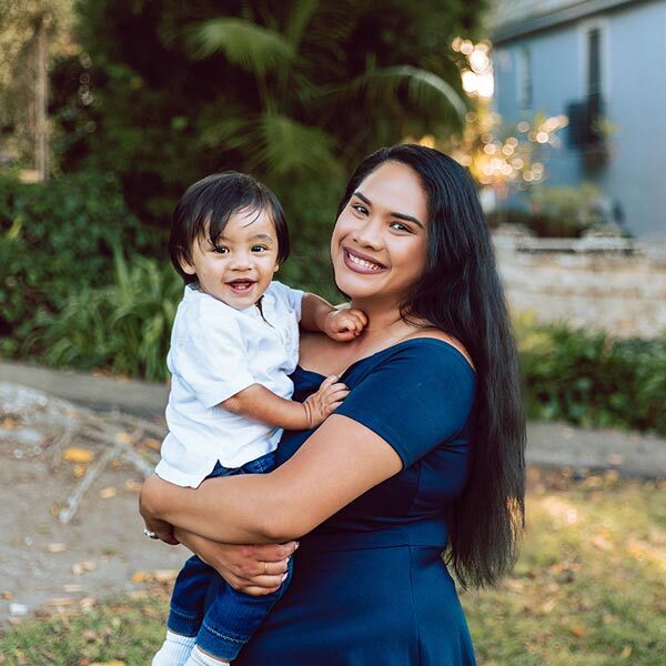 A smiling mother carrying a child